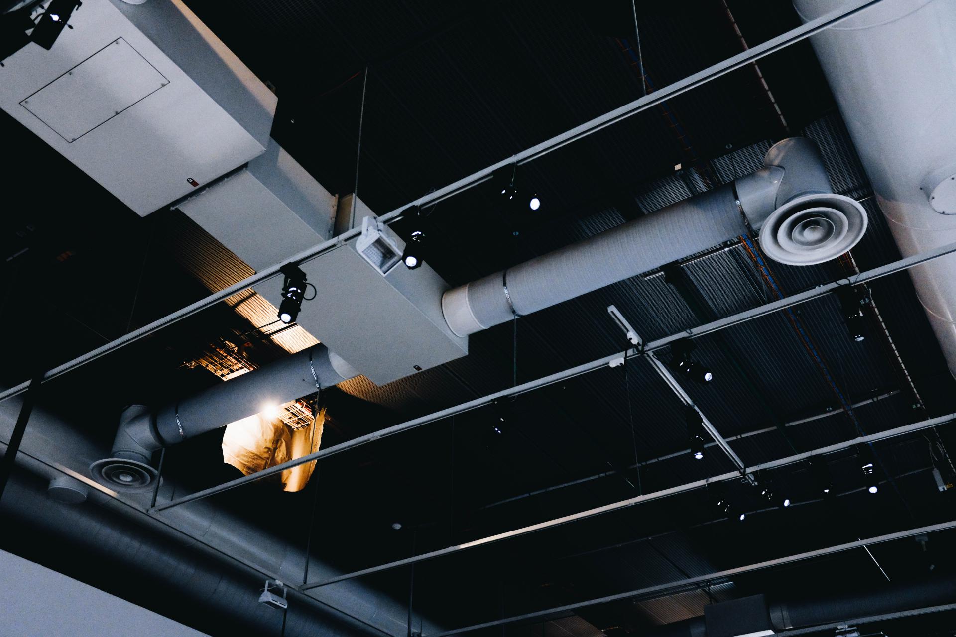 387low-angle-shot-of-a-metal-black-ceiling-with-white-ventilation-pipes.jpg